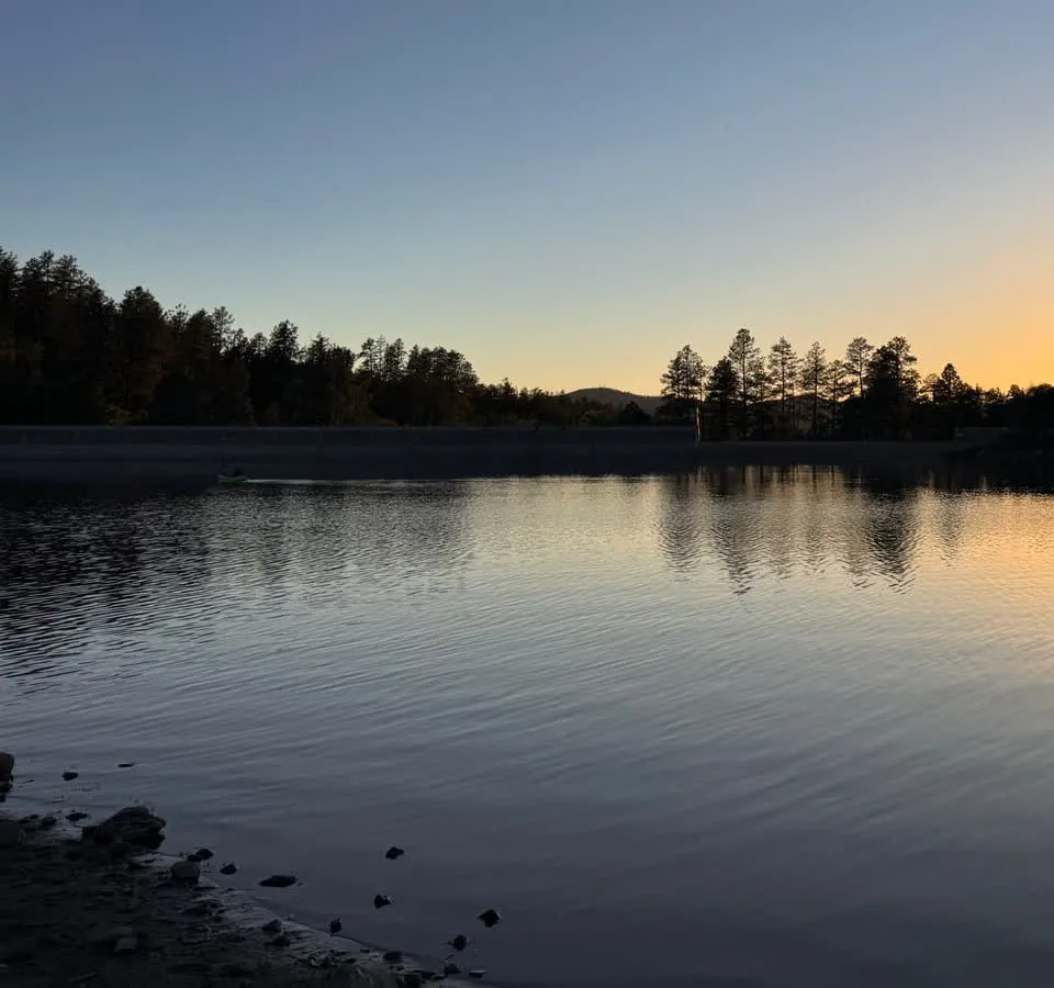 Calm water at dusk on a pine-ringed lake near Prescott
