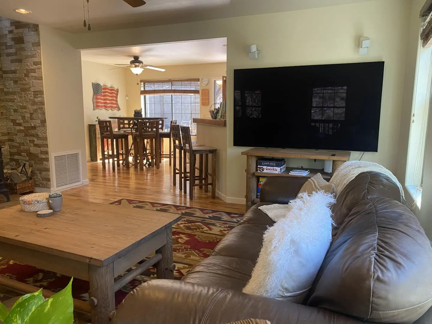 Open-plan living room with a sectional, smart TV, and the kitchen beyond