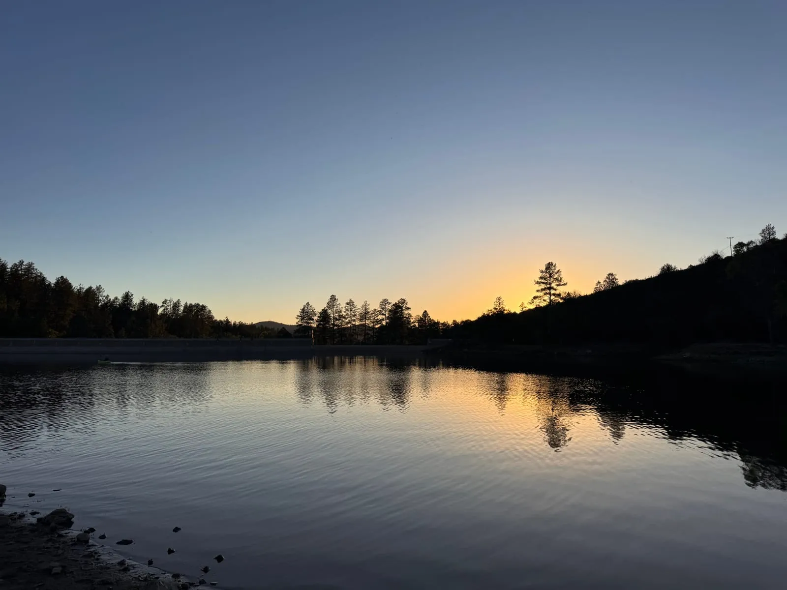 Sunset over a quiet lake in the pines near the cabin
