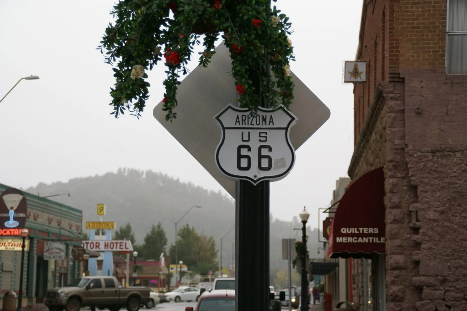 A US Route 66 highway shield sign on a street in Williams, Arizona