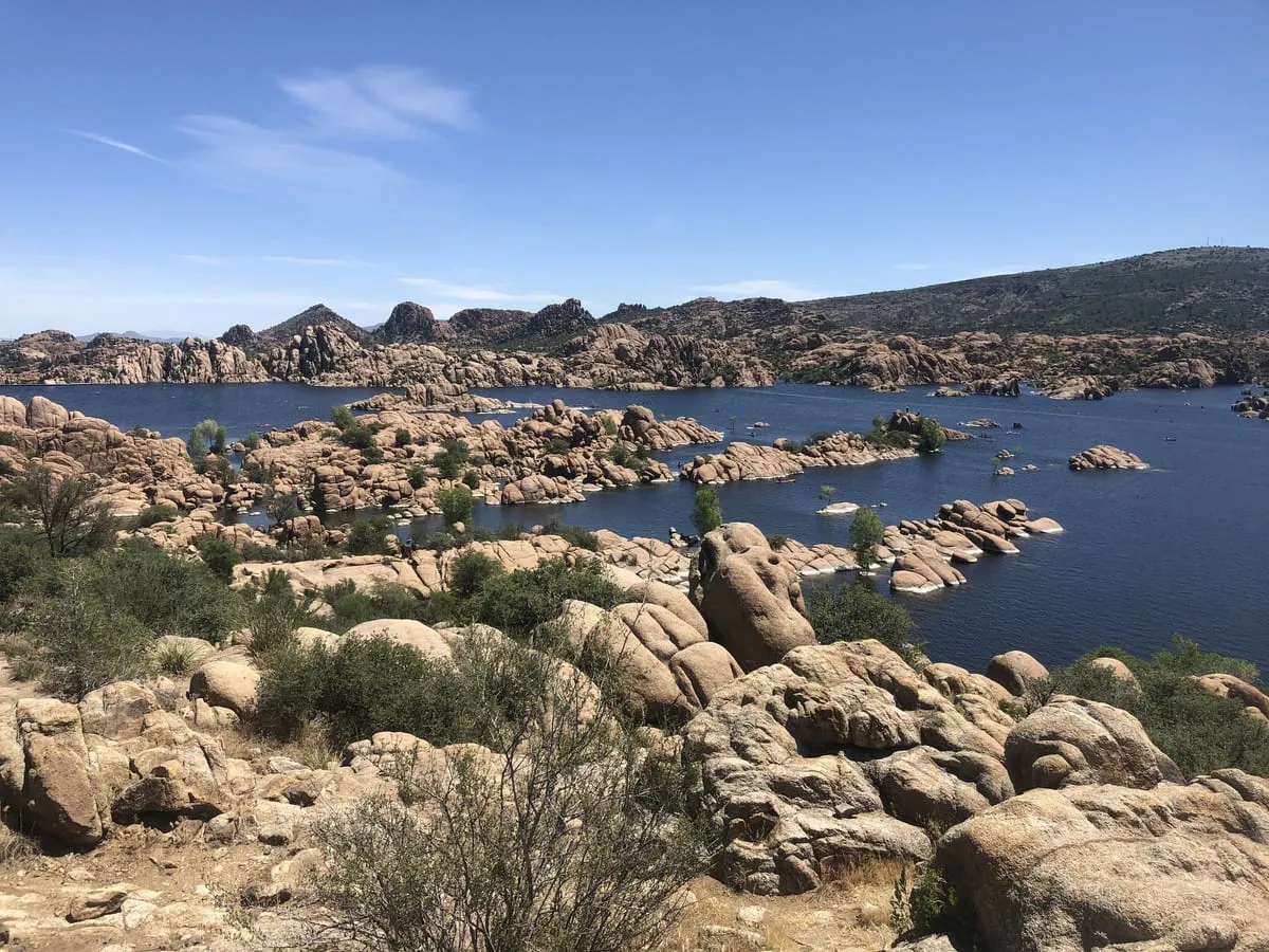 The granite boulders of the Dells meeting the blue water of Watson Lake