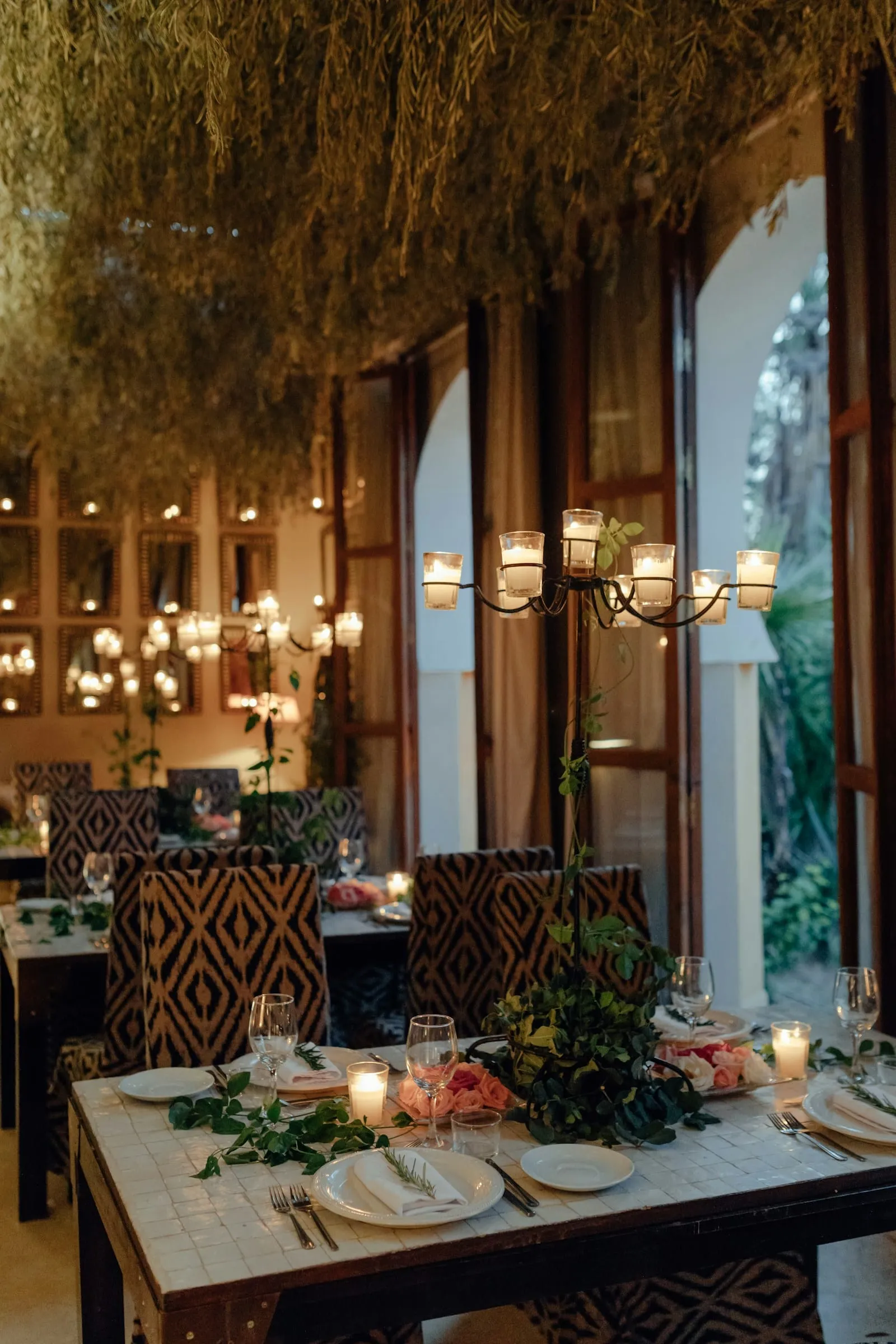 A warm, candle-lit restaurant table set for dinner